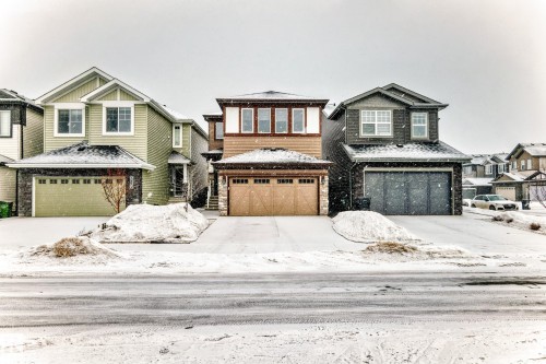 View of front of house with an attached garage, stone siding, and concrete driveway - 5110 23A Avenue, Edmonton, AB - Outdoor With Facade