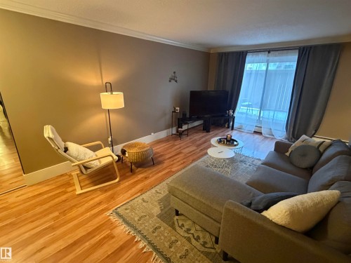 Living area with Laminate flooring and crown molding - 102 11303 103 Avenue, Edmonton, AB - Indoor Photo Showing Living Room