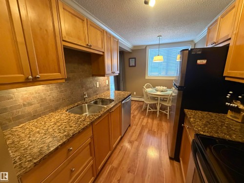 Stainless Steele Appliances & Crown Moldings - 102 11303 103 Avenue, Edmonton, AB - Indoor Photo Showing Kitchen With Double Sink