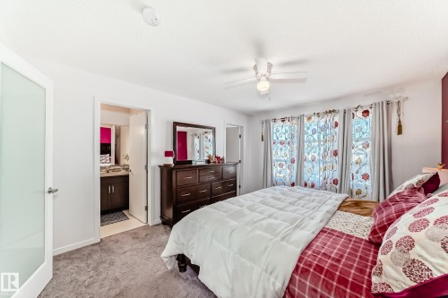 Bedroom with light carpet, a ceiling fan, and ensuite bathroom - 3059 Checknita Way, Edmonton, AB - Indoor Photo Showing Bedroom