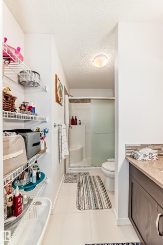 Bathroom featuring a textured ceiling, a shower stall, vanity, and light tile patterned flooring - 3059 Checknita Way, Edmonton, AB - Indoor Photo Showing Bathroom