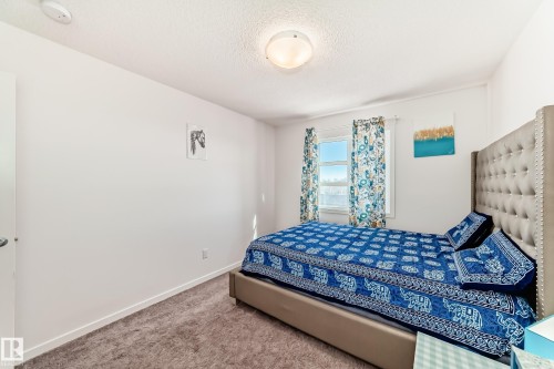 Carpeted bedroom featuring baseboards and a textured ceiling - 3059 Checknita Way, Edmonton, AB - Indoor Photo Showing Bedroom