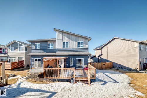 Rear view of house featuring board and batten siding and a wooden deck - 3059 Checknita Way, Edmonton, AB - Outdoor With Deck Patio Veranda