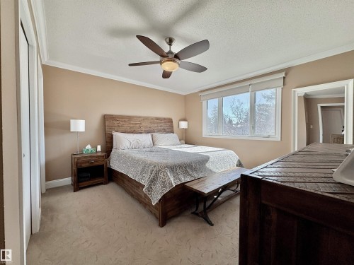 Bedroom with ornamental molding, light colored carpet, a ceiling fan, and a textured ceiling - 4 Wolf Crescent Nw, Edmonton, AB - Indoor Photo Showing Bedroom