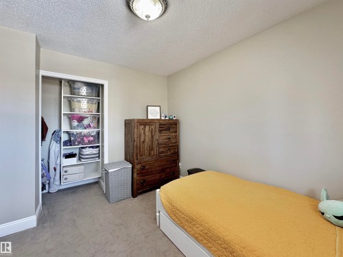 Bedroom featuring a textured ceiling, light colored carpet, and a closet - 4 Wolf Crescent Nw, Edmonton, AB - Indoor Photo Showing Bedroom