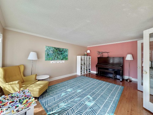 Living area featuring hardwood / wood-style flooring, a textured ceiling, and ornamental molding - 4 Wolf Crescent Nw, Edmonton, AB - Indoor