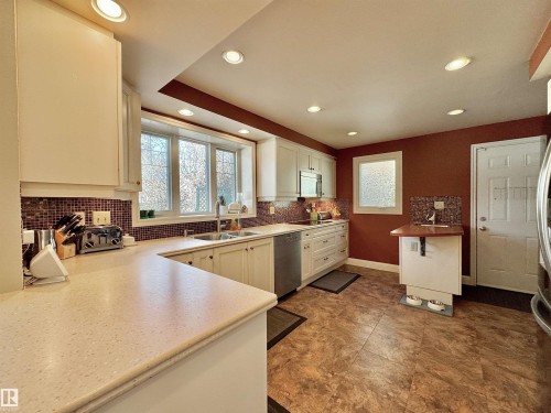 Kitchen with backsplash, white cabinets, stainless steel appliances, and recessed lighting - 4 Wolf Crescent Nw, Edmonton, AB - Indoor Photo Showing Kitchen With Double Sink