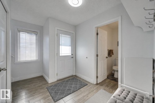 Foyer with light wood-style flooring and a textured ceiling - 59 14803 Miller Boulevard, Edmonton, AB - Indoor Photo Showing Other Room