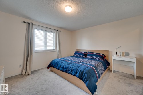 Bedroom with carpet and a textured ceiling - 59 14803 Miller Boulevard, Edmonton, AB - Indoor Photo Showing Bedroom