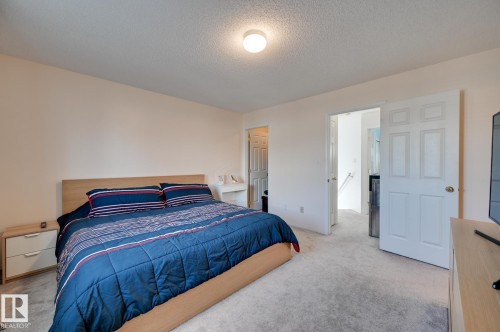 Bedroom featuring light carpet and a textured ceiling - 59 14803 Miller Boulevard, Edmonton, AB - Indoor Photo Showing Bedroom