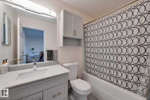 Bathroom with vanity, shower / bath combo, a textured ceiling, and connected bathroom - 59 14803 Miller Boulevard, Edmonton, AB - Indoor Photo Showing Bathroom