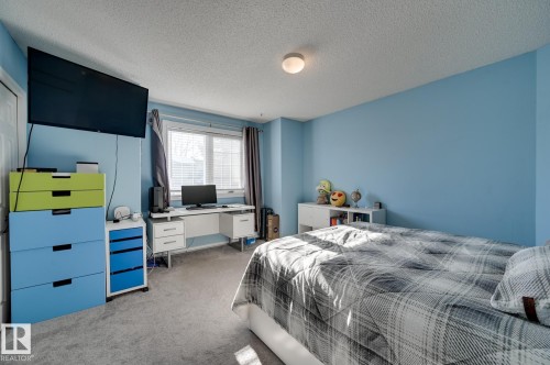 Bedroom featuring carpet floors, an office area, and a textured ceiling - 59 14803 Miller Boulevard, Edmonton, AB - Indoor Photo Showing Bedroom