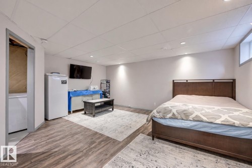 Bedroom with white refrigerator, a drop ceiling, light wood-style floors, and recessed lighting - 59 14803 Miller Boulevard, Edmonton, AB - Indoor Photo Showing Bedroom