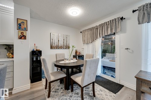 Dining space with a textured ceiling and light wood-style floors - 59 14803 Miller Boulevard, Edmonton, AB - Indoor Photo Showing Dining Room