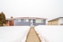 The property features light blue siding, a dark red roof, and a front walkway leading to the entrance - 7911 145 Avenue Nw, Edmonton, AB  - Outdoor 