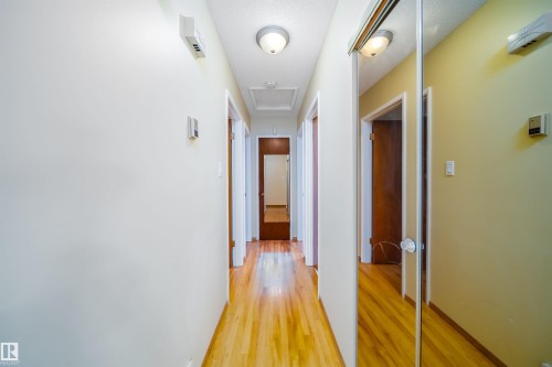 Hallway with hardwood flooring, light-toned walls, and flush mount ceiling lights - 7911 145 Avenue Nw, Edmonton, AB - Indoor Photo Showing Other Room