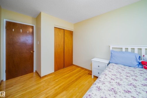 This room features hardwood floors and a closet with bi-fold doors - 7911 145 Avenue Nw, Edmonton, AB - Indoor Photo Showing Bedroom