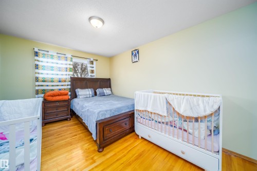 Well-lit room featuring hardwood floors and a ceiling light fixture - 7911 145 Avenue Nw, Edmonton, AB - Indoor Photo Showing Bedroom