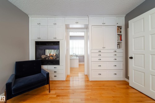 Primary bedroom showing fireplace and build in shelving - 8332 120 Street, Edmonton, AB - Indoor