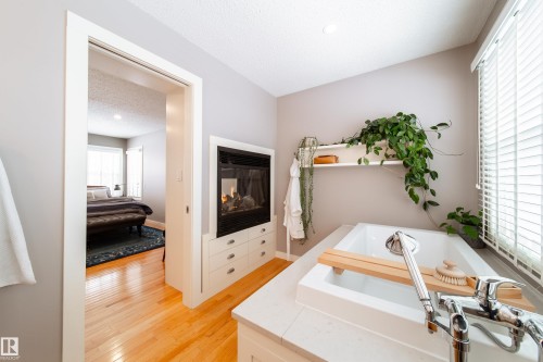 ensuite with soaker tub looking into see-through fireplace into bedroom - 8332 120 Street, Edmonton, AB - Indoor
