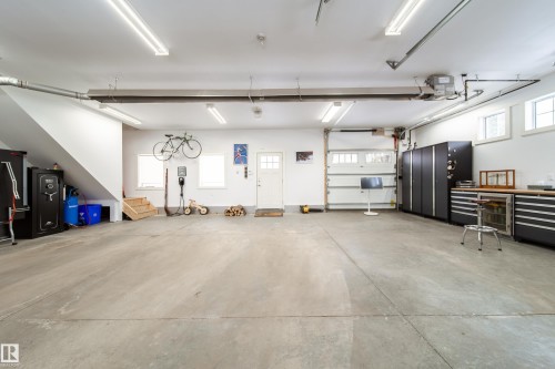 Built in 2016, the 36 x 27 ft. luxury garage with stairs leading to loft is a dream come true.  With 2 overhead doors for vehicle entry and 1 overhead door for backyard access. - 8332 120 Street, Edmonton, AB - Indoor Photo Showing Garage