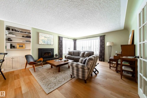 New Vermont wood burning insert fireplace.  Very bright room with large windows covered by Elite Blinds.  Mostly the same blinds throughout - 8332 120 Street, Edmonton, AB - Indoor Photo Showing Living Room With Fireplace