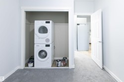 Laundry area with stacked washer and clothes dryer and carpet - 