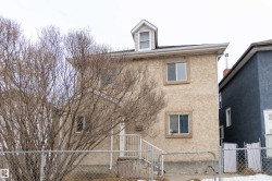 View of front of house featuring stucco siding and a gate - 