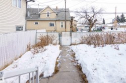 Yard covered in snow featuring a gate and a fenced backyard - 