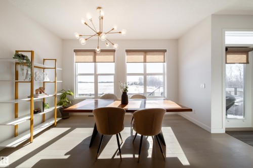 Dining room featuring wood finished floors, suspended lighting, and plenty of natural light - 19 Sturtz Place, Leduc, AB - Indoor Photo Showing Dining Room