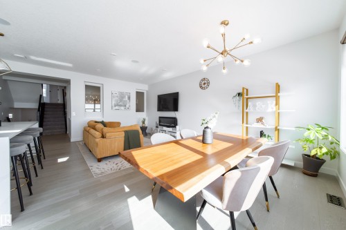 Dining room with light wood-style flooring and a chandelier - 19 Sturtz Place, Leduc, AB - Indoor Photo Showing Dining Room