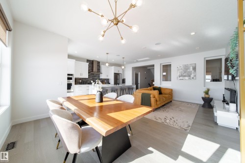 Dining room featuring light wood-type flooring and a chandelier - 19 Sturtz Place, Leduc, AB - Indoor Photo Showing Dining Room