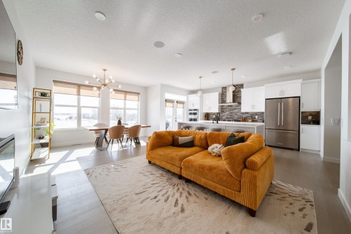 Living area with light wood-type flooring, hanging lights, and a textured ceiling - 19 Sturtz Place, Leduc, AB - Indoor