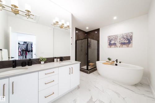 Full bath featuring a marble finish shower, double vanity, a walk in closet, a soaking tub, and light marble finish flooring - 19 Sturtz Place, Leduc, AB - Indoor Photo Showing Bathroom