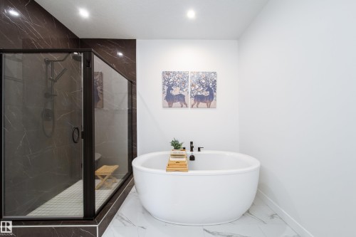 Full bath with marble look tiles, a marble finish shower, a soaking tub, and recessed lighting - 19 Sturtz Place, Leduc, AB - Indoor Photo Showing Bathroom