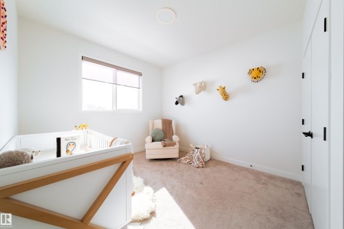 Carpeted bedroom featuring a crib and a closet - 19 Sturtz Place, Leduc, AB - Indoor