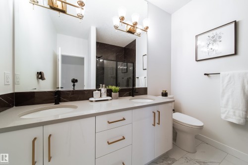 Full bath featuring double vanity, a shower stall, and light marble finish floors - 19 Sturtz Place, Leduc, AB - Indoor Photo Showing Bathroom