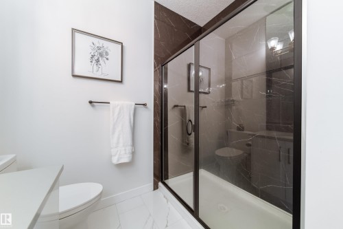 Full bath with a marble finish shower, vanity, and light marble finish floors - 19 Sturtz Place, Leduc, AB - Indoor Photo Showing Bathroom