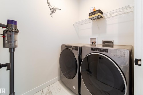 Laundry area with light marble finish floors and separate washer and dryer - 19 Sturtz Place, Leduc, AB - Indoor Photo Showing Laundry Room