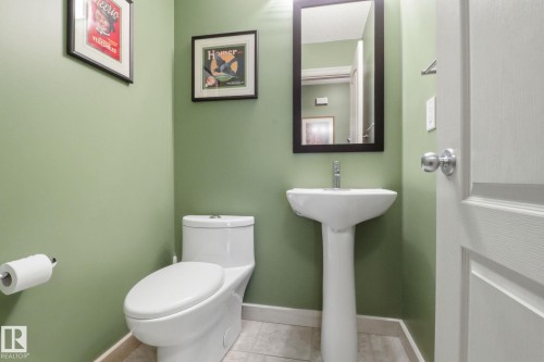 Half bath featuring toilet and light tile patterned flooring - 8311 11 Avenue, Edmonton, AB - Indoor Photo Showing Bathroom