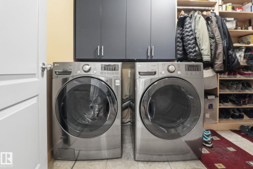 Laundry room with light tile patterned floors, cabinet space, and washer and dryer - 8311 11 Avenue, Edmonton, AB - Indoor Photo Showing Laundry Room