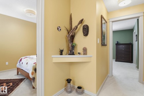 Hallway with light carpet and a textured ceiling - 8311 11 Avenue, Edmonton, AB - Indoor
