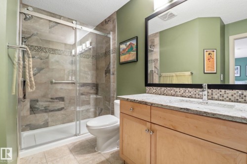 Bathroom featuring vanity, a shower stall, light tile patterned flooring, and a textured ceiling - 8311 11 Avenue, Edmonton, AB - Indoor Photo Showing Bathroom