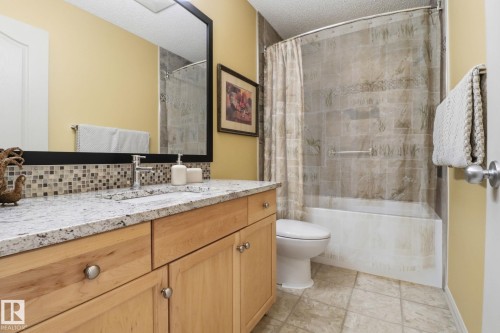 Bathroom featuring vanity, shower / tub combo with curtain, and a textured ceiling - 8311 11 Avenue, Edmonton, AB - Indoor Photo Showing Bathroom