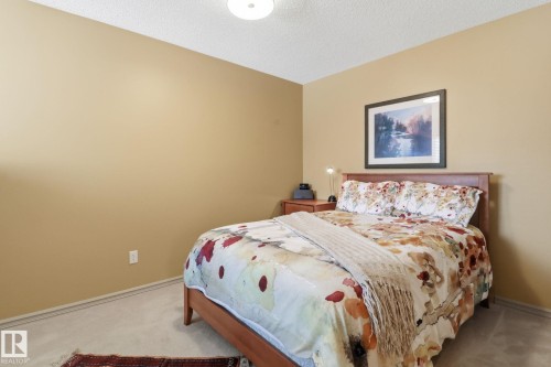 Bedroom with light carpet and a textured ceiling - 8311 11 Avenue, Edmonton, AB - Indoor Photo Showing Bedroom