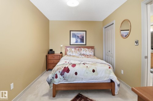 Bedroom with a closet, a textured ceiling, and light carpet - 8311 11 Avenue, Edmonton, AB - Indoor Photo Showing Bedroom