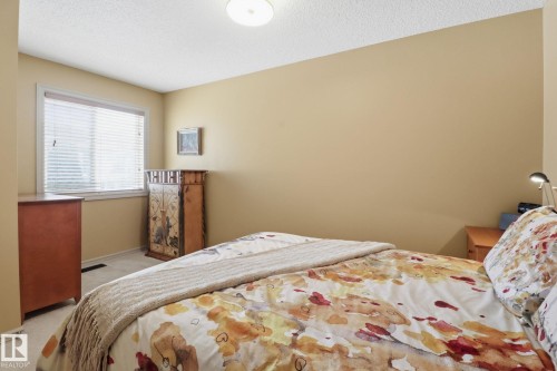 Bedroom with light carpet and a textured ceiling - 8311 11 Avenue, Edmonton, AB - Indoor Photo Showing Bedroom