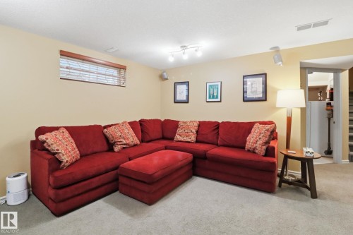 Carpeted living room with baseboards and stairs - 8311 11 Avenue, Edmonton, AB - Indoor