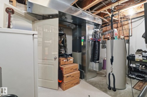 Unfinished basement featuring gas water heater and heating unit - 8311 11 Avenue, Edmonton, AB - Indoor Photo Showing Basement
