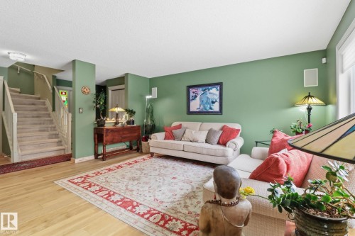 Living room with stairs and wood finished floors - 8311 11 Avenue, Edmonton, AB - Indoor Photo Showing Living Room